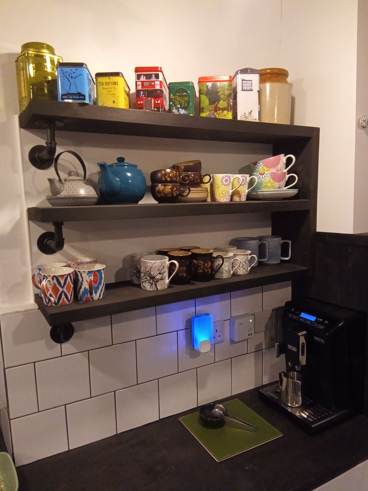 Open shelving with tea tins, teapots and a collection of mugs